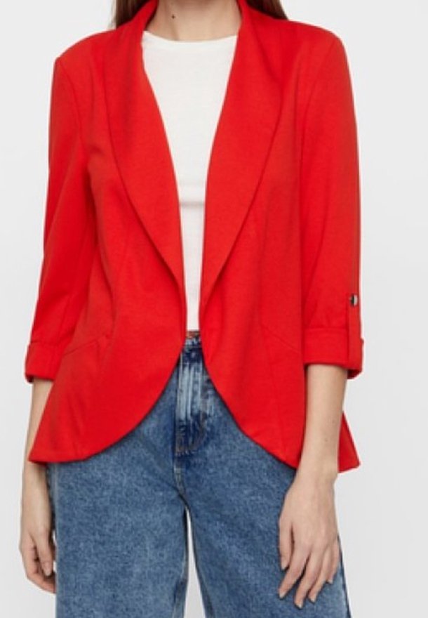 Punainen, kevyt bleiseri, jossa on lovikaulus, käännettävät hihat ja kaksi etutaskua, yhdistetty vaaleansinisiin korkeavyötäröisiin farkkuihin.