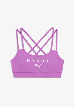 Violetti urheilurintaliivit ohuilla ristiin menevillä olkaimilla ja valkoisella "HYROX"-tekstillä sekä Puma-logolla edessä.
