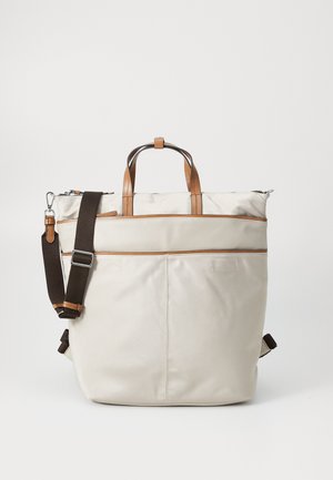 Borsa tote beige chiaro con dettagli in pelle marrone, manici superiori e una tracolla regolabile marrone scuro. Chiusura a zip con tasca frontale.
