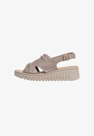 Nahast sandaal taupe-pruunis toonis, avatud varbakujuga, külgedel lõhikute ja reguleeritava pahkluu rihmaga. Omab jämeda soonilise taldiga tallaplaati.