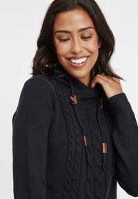 Granatowy dzianinowy hoodie z wzorem w warkocz, regulowane sznurki w brązowych akcentach oraz teksturowany materiał.