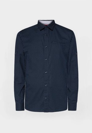 Navyblaues Hemd mit langen Ärmeln, weißen Punkten, Kragen und einer Brusttasche; aus glattem Stoff mit leichtem Glanz.