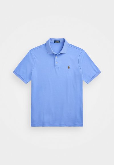 Camisa polo de color azul claro con mangas cortas, cuello, tapeta de tres botones y un pequeño logotipo bordado en el lado izquierdo del pecho. Textura suave.
