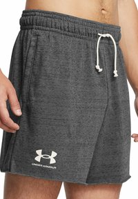 Grå sportshorts tillverkade av mjukt tyg. Har ett elastiskt midjeband med en vit dragsko och sidofickor. Logotyp i vitt på fållen.