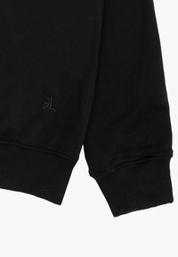 Zwarte sweatshirt met ribgebreide manchetten en zoom. Heeft een subtiele opgebosde logo op de mouw. Het materiaal lijkt zacht en iets textuur te hebben.