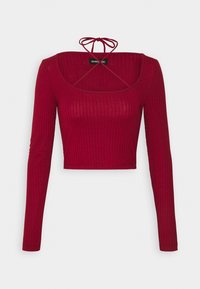 Czerwona, żebrowana bluzka z długim rękawem, z kwadratowym dekoltem i wiązaniem z tyłu. Posiada dopasowany krój i skróconą długość.