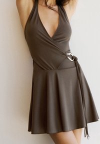 Robe portefeuille marron en tissu lisse, avec un décolleté en V, un corsage ajusté, une jupe évasée et un accent argenté sur le lien de taille.