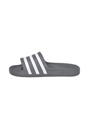 Chancla tipo slide gris de Adidas con tres franjas blancas en la correa y plantilla moldeada para mayor comodidad, mostrada de lado.