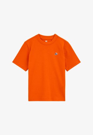 Svijetlo narančasta pamučna majica kratkih rukava s okruglim izrezom i malim plavo-bijelim vezenim logotipom na lijevoj strani prsa.