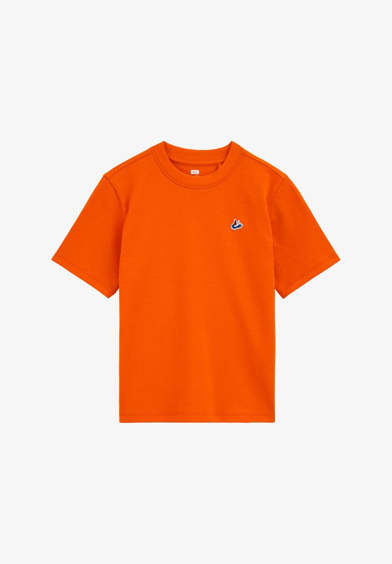 Ryškiai oranžinė medvilninė trumpomis rankovėmis marškinėliai su apvalia apykakle ir mažu mėlynos ir baltos spalvos siuvinėtu logotipu kairėje krūtinės pusėje.