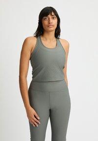 Gray ribbed sports tank top with a rounded neckline, paired with matching high-waisted leggings. Both pieces feature a textured fabric.