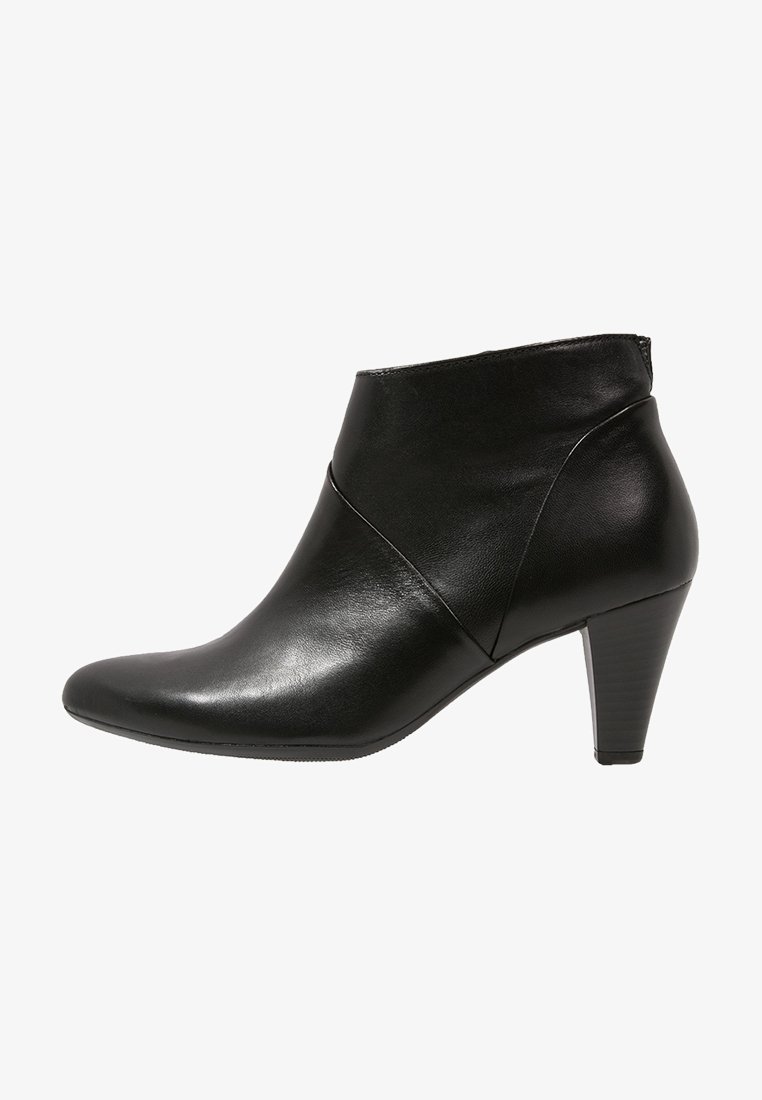 Bottes courtes en cuir noir avec un bout pointu, des détails de ligne asymétrique et un talon modéré. Texture lisse et design épuré.