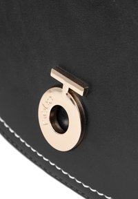 Borsa a mano in pelle nera caratterizzata da un accento in metallo dorato rotondo con logo inciso e cuciture bianche a contrasto lungo il bordo.