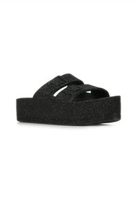 Sandali platform neri con una texture glitterata, dotati di due ampie cinghie incrociate e una suola spessa per maggiore altezza e comfort.