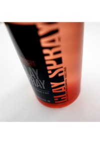 Contenitore per spray di argilla con forma cilindrica, materiali nero opaco e arancione trasparente, testo bianco e arancione in grassetto, design minimalista.