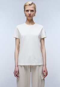 Lichtbeige katoenen t-shirt met korte mouwen en een ronde hals. Gave textuur, eenvoudig ontwerp en een relaxte pasvorm.