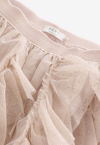 Różowy tiulowy spódniczka z falbaniastymi warstwami, z złotymi plamkami. Elastyczny pas dla wygody. Widoczna metka marki "NEXT".