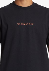 Black cotton t-shirt featuring a small, orange "Quiksilver" logo centered on the chest. Simple crew neckline and short sleeves.