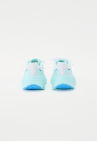 Hellblaue Sportschuhe mit einer strukturierten Sohle, einem Mesh-Obermaterial und einer gepolsterten Ferse. Die Schnürsenkel sind weiß und haben ein glattes, geschichtetes Design.