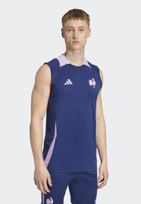 Mornarska bezrukavna sportska majica s laganim ružičastim detaljima i logotipom pijetla na prsima. Izrađena od laganog materijala, pogodna za sportske aktivnosti.