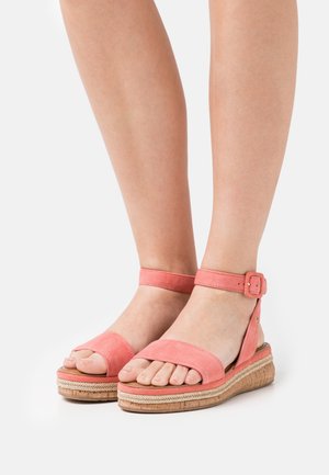 Sandales en suède rose avec bride et boucle à la cheville, dotées d'une semelle plateforme texturée et d'un design à bout ouvert.