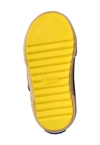 Suola della scarpa in gomma gialla con scanalature orizzontali per la presa; logo visibile vicino al tallone; bordi beige, design minimale.