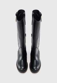 Bottes noires en cuir jusqu'au genou avec un design épuré, semelle en caoutchouc plate, zips sur le côté et texture lisse.