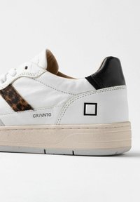 Sneaker bianco in pelle con un accento in stampa leopardata sul lato, tallone nero e suola in gomma con finitura texturizzata.