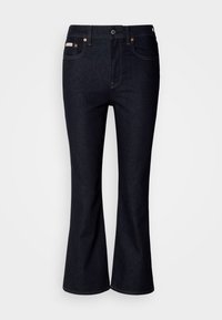 Σκούρο μπλε τζιν καμπάνα από τζιν ύφασμα, με κλασικό σχέδιο πέντε τσεπών, μεταλλικό κουμπί κλεισίματος και ραφές σε αντίθετο χρώμα.