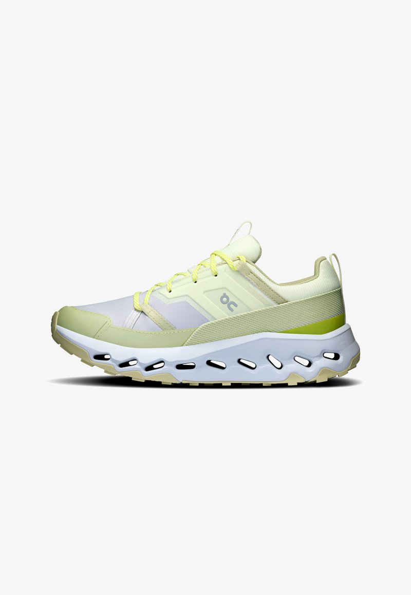 Baskets de course vert clair et blanches avec une tige en mesh, des lacets jaunes contrastants et une épaisse semelle blanche et beige avec des découpes.