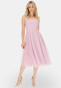 Jasnoróżowa sukienka bez ramiączek z dopasowanym topem i zwiewnym dołem, wykonana z miękkiego, lekkiego materiału. Gładka tekstura, długość do połowy łydki.
