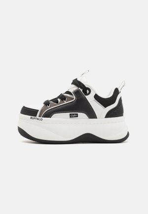 Platform sneakers featuring a black and white design, mesh accents, textured detailing, and a prominent logo on the side.