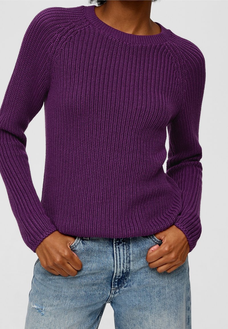 Fialový žebrovaný pletený svetr s dlouhými rukávy a kulatým výstřihem, doplněný světlými modrými džínami s potrhaným vzhledem. Pohodlná textura, přiléhavý střih.