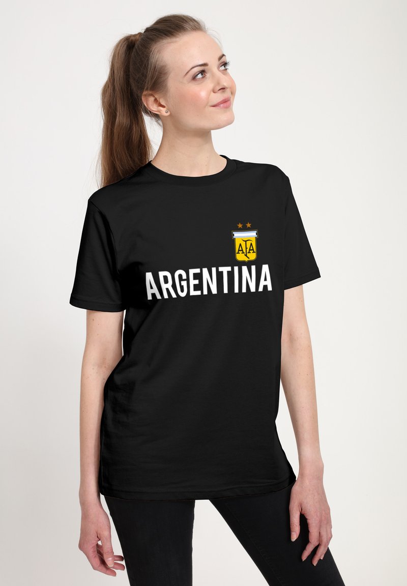 Černé bavlněné tričko s nápisem "ARGENTINA" v bílé barvě a barevným erbem nahoře. Krátké rukávy a volný střih.