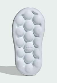 Suola delle calzature Adidas in grigio chiaro, realizzata in schiuma testurizzata, caratterizzata da indentazioni circolari e logo del marchio inciso, progettata per il comfort.
