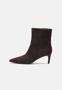 Brune semskede ankelstøvler med spidse tæer og 7,5 cm hæl, der har en glat tekstur og minimalistisk design. Lynlåslukning bagpå.