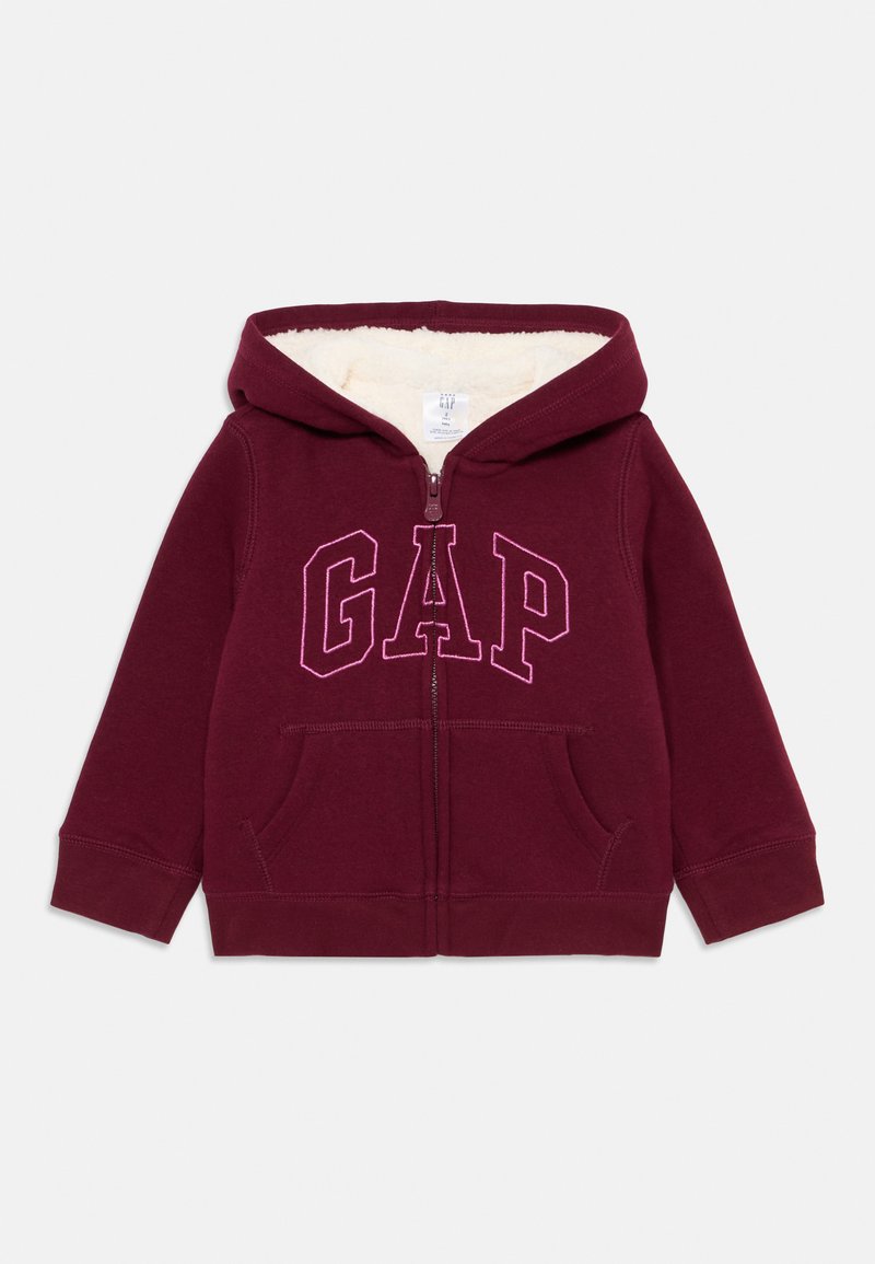 Felpa per bambino color marsala con zip frontale, tasche a marsupio, cappuccio foderato in pile e la scritta "GAP" ricamata in grandi lettere rosa sul petto.