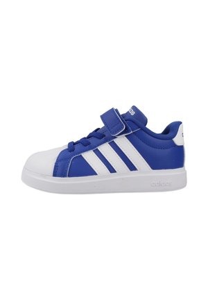 Zapatilla Adidas azul y blanca con cierre de velcro y cordones, con tres rayas blancas en el lateral y una suela de goma blanca.
