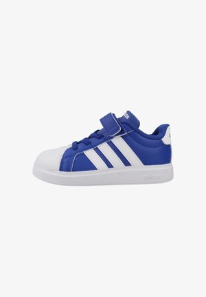 Zapatilla Adidas azul y blanca con cierre de velcro y cordones, con tres rayas blancas en el lateral y una suela de goma blanca.