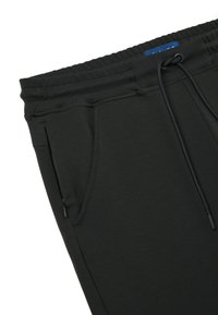 Dunkelgrüne Jogginghosen aus weichem Material, mit einem Kordelzugbund, Seitentaschen und einer glatten Textur. Mit Reißverschlusstasche.