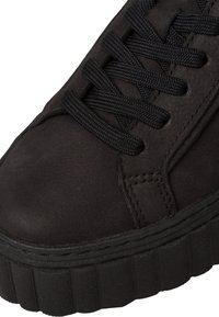 Baskets montantes noires en daim avec une surface texturée, dotées de lacets noirs et d'une semelle en caoutchouc épaisse et striée.