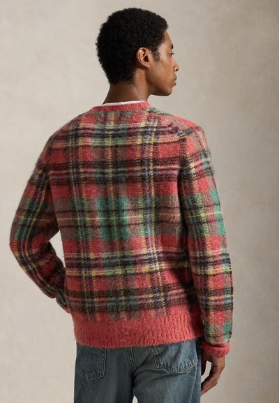 Tröja i ullblandning i rosa med ett flerfärgat rutigt mönster. Har en mjuk textur, rund halsringning och ribbade muddar och fåll.