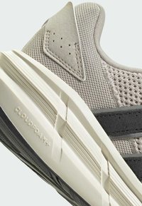Gray sneaker with mesh and leather upper, white cushioning midsole, textured black outsole, and subtle branding on the side.