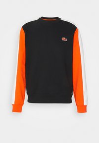 Sudadera negra con mangas en naranja y blanco. Cuenta con cuello redondo, puños de canalé y logo bordado en el pecho. Textura suave.