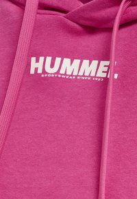 Roze hoodie van fleece stof, met een witte bedrukte logo "HUMMER" en de tekst "SPORTSWEAR SINCE 1923" op de borst.