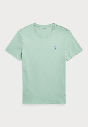 T-shirt en coton vert menthe avec des manches courtes, col ras du cou et petit logo bleu sur la poitrine gauche. Texture lisse et design simple.