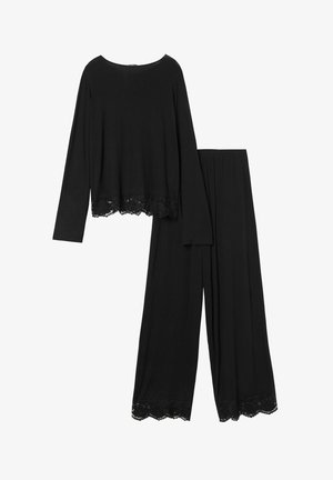 Top negro de manga larga con encaje en el dobladillo, combinado con pantalones anchos negros que también tienen detalles de encaje en los puños. Textura de tela suave.