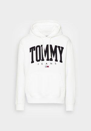 Biała bluza z kapturem z dużym czarnym napisem "TOMMY", mniejszym napisem "JEANS" poniżej oraz małym czerwono-biało-niebieskim logo Tommy Hilfiger na przedniej kieszeni.
