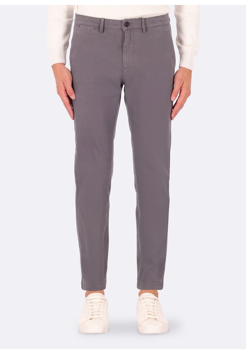 Chinos di cotone grigi con una vestibilità slim, dotati di chiusura con bottone frontale, tasche laterali e una texture liscia. Indossati con sneakers bianche.