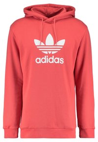 Felpa corallo realizzata in morbido tessuto, con tasca a marsupio, cappuccio con cordino e logo Adidas bianco con tre strisce sopra.